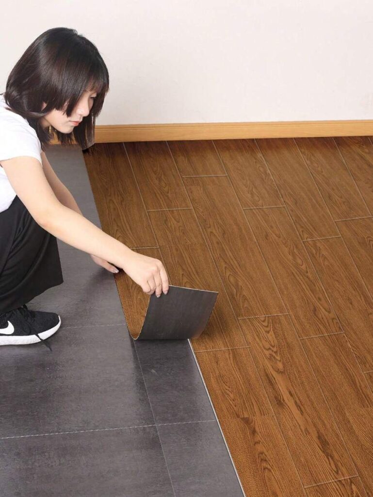 Pessoa aplicando piso laminado.