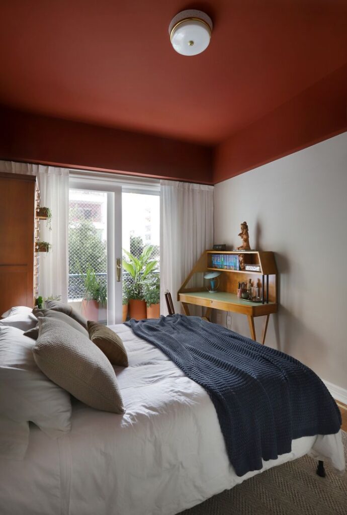 Quarto de casal com teto colorido em tonalidade terrosa.