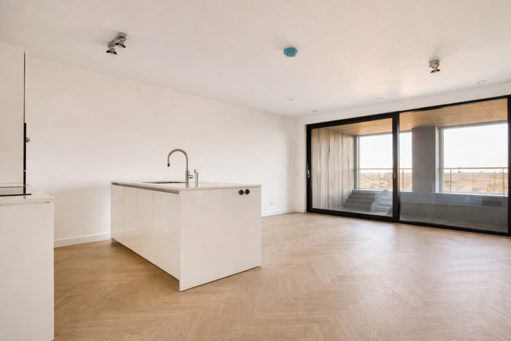 Quando o mesmo revestimento é aplicado em toda a cozinha integrada com sala de jantar e estar, o ambiente parece mais amplo e harmonioso.
